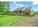 Charming brick home with a lush, landscaped front yard and inviting covered porch at 7189 Bovine Ln # 28, Harrisburg, NC 28075