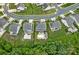 Aerial view of the property featuring a backyard with a pool and patio, well-manicured lawns, and mature trees at 7339 Millstone Sw Cir, Concord, NC 28025