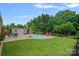 This backyard features an inground pool, patio, outdoor shed, and lush landscaping at 7339 Millstone Sw Cir, Concord, NC 28025