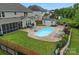 Aerial view showcases a beautiful backyard with a pool, lounge chairs, outdoor seating, and well-maintained landscaping at 7339 Millstone Sw Cir, Concord, NC 28025