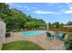 This backyard features a beautiful inground pool, patio, seating, and lush landscaping at 7339 Millstone Sw Cir, Concord, NC 28025