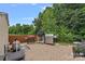 This backyard has brick pavers, multiple outdoor grills, and a border of mature trees offering private outdoor cooking at 7339 Millstone Sw Cir, Concord, NC 28025