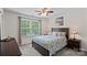 Bedroom featuring a ceiling fan, large window, and wood furniture at 7339 Millstone Sw Cir, Concord, NC 28025