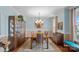 Elegant dining room featuring hardwood floors, a large table with seating for six, and a display cabinet at 7339 Millstone Sw Cir, Concord, NC 28025