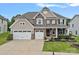 Charming two-story home with a three car garage, stone accents, a manicured lawn and covered front porch at 7339 Millstone Sw Cir, Concord, NC 28025