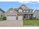 Charming two-story home with a three car garage, stone accents, a manicured lawn and covered front porch at 7339 Millstone Sw Cir, Concord, NC 28025
