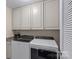 This laundry room features white washer and dryer and lots of above storage space and cabinets at 7339 Millstone Sw Cir, Concord, NC 28025