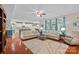 Open-concept living room with hardwood floors flowing into the kitchen and dining areas with bright windows at 7339 Millstone Sw Cir, Concord, NC 28025