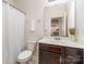 Bright bathroom featuring a white shower curtain, toilet, and dark vanity at 755 Lagan Ct, Fort Mill, SC 29715