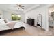 Serene main bedroom featuring a tray ceiling, large window, and a walk-in closet, bathed in natural light at 755 Lagan Ct, Fort Mill, SC 29715