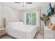 Cozy bedroom featuring a tufted headboard, large window, and ceiling fan at 8108 Christmas Ct, Charlotte, NC 28216