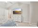 Bright bedroom with TV, dresser, and ceiling fan; neutral color palette at 8108 Christmas Ct, Charlotte, NC 28216