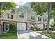 Two-story townhouse with a one-car garage, lush landscaping, and a welcoming front porch at 8108 Christmas Ct, Charlotte, NC 28216