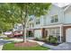 Charming townhouse featuring a brick facade, well-kept landscaping, and an inviting entryway with seating at 8108 Christmas Ct, Charlotte, NC 28216