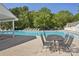 Refreshing community pool offering tables, seating, and trees for leisure and social gatherings in a scenic setting at 8108 Christmas Ct, Charlotte, NC 28216