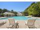 Relaxing community pool area with lounge chairs, blue skies, and mature trees creating a serene outdoor environment at 8108 Christmas Ct, Charlotte, NC 28216