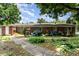 Brick ranch-style home featuring a tidy yard with flowering bushes beneath windows at 839 Montford Dr, Charlotte, NC 28209