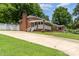 Exterior view of the brick home with a long driveway and well-maintained landscaping at 839 Montford Dr, Charlotte, NC 28209