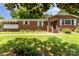 Charming brick home featuring manicured lawn, mature trees, and traditional architectural details at 839 Montford Dr, Charlotte, NC 28209