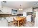 Bright kitchen with white cabinetry and countertops, stainless steel appliances, and a cozy dining area at 839 Montford Dr, Charlotte, NC 28209