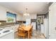 Traditional kitchen features white cabinets, modern appliances, and adjacent dining area with wood table and chairs at 839 Montford Dr, Charlotte, NC 28209