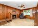 Comfortable living room featuring a brick fireplace, wood-paneled walls, and a cozy armchair at 839 Montford Dr, Charlotte, NC 28209