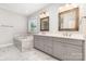 Bright bathroom with a double sink vanity, soaking tub, and large, framed mirrors at 8709 Raven Top Dr, Mint Hill, NC 28227