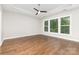 Bright bedroom with hardwood floors, tray ceiling, and large window overlooking the outdoors at 8709 Raven Top Dr, Mint Hill, NC 28227
