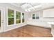 Bright dining area with hardwood floors, white cabinets, and large windows overlooking the backyard at 8709 Raven Top Dr, Mint Hill, NC 28227