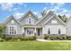 Charming front exterior with a welcoming porch, stone accents and manicured lawn at 8709 Raven Top Dr, Mint Hill, NC 28227