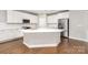 Modern kitchen featuring a large island, stainless steel appliances, white cabinetry, and hardwood floors at 8709 Raven Top Dr, Mint Hill, NC 28227