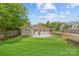 This home features a spacious backyard with lush green lawn, partial fence, patio, and stairs at 933 Old Charlotte Rd, Concord, NC 28027