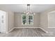 Dining area with a modern light fixture, hardwood floors, and ample natural light at 933 Old Charlotte Rd, Concord, NC 28027