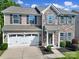 Charming two-story home featuring stone accents, a two-car garage, and beautifully landscaped front yard at 1012 Kings Bottom Dr, Fort Mill, SC 29715