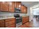 Modern kitchen features stainless steel appliances, wood cabinets, granite countertops, and wood floors at 1012 Kings Bottom Dr, Fort Mill, SC 29715