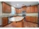 Bright kitchen boasts wooden cabinets, granite countertops, stainless steel appliances, and a convenient center island at 1012 Kings Bottom Dr, Fort Mill, SC 29715