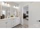 Bathroom boasting double sinks, white cabinetry, and a glimpse into the adjacent bedroom at 1036 Riverwalk Pkwy, Rock Hill, SC 29730