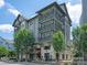 Multi-story building with balconies and a ground-level restaurant; lush trees in the foreground at 1036 Riverwalk Pkwy, Rock Hill, SC 29730