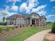 Beautiful clubhouse with stone and siding, a covered entrance, landscaping, and a sidewalk at 1036 Riverwalk Pkwy, Rock Hill, SC 29730