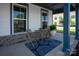 Cozy front porch seating area with a table and chairs on a stylish blue patterned rug at 1036 Riverwalk Pkwy, Rock Hill, SC 29730