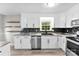 Well-lit kitchen featuring floating shelves, stainless steel appliances, and newly finished countertops at 103A N Tracy St, Kings Mountain, NC 28086