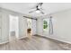 Bright main bedroom featuring a ceiling fan, light gray walls, wood floors, an ensuite bathroom and walk-in closet at 103A N Tracy St, Kings Mountain, NC 28086