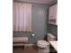 Modest bathroom featuring toilet, white cabinets, and a small white bench at 1051 S Brady Ave, Newton, NC 28658
