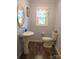 Compact bathroom with pedestal sink, toilet, and window with patterned valance at 1051 S Brady Ave, Newton, NC 28658