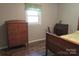 Bedroom featuring a dresser with knobs, side window and wooden bed frame at 1051 S Brady Ave, Newton, NC 28658