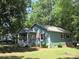 Charming home featuring a covered porch, colorful shutters, and lush lawn at 1051 S Brady Ave, Newton, NC 28658