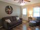 Comfortable living room with a sofa, ceiling fan, and large round wall decor at 1051 S Brady Ave, Newton, NC 28658