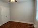 Simple bedroom with hardwood floors, a window for natural light, and a double-door closet at 10715 Tom Short Rd, Charlotte, NC 28277