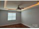 Serene bedroom with a tray ceiling, modern ceiling fan, hardwood floors, and a window at 10715 Tom Short Rd, Charlotte, NC 28277