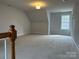 Bright bonus room with neutral carpeting, trim, natural light, and vaulted ceilings at 10715 Tom Short Rd, Charlotte, NC 28277